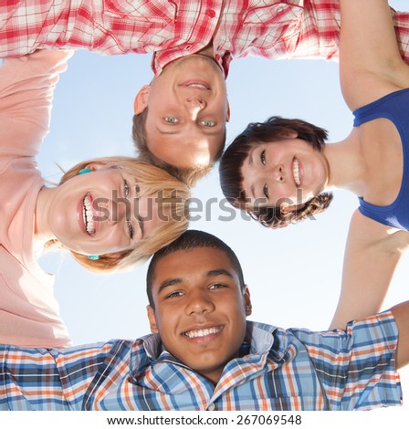 Group of young people outdoor hug each other acrosss blue sky