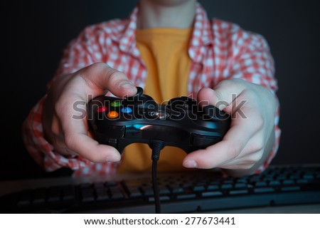 He like play and win video games. In blue light of display emotional kid play computer games online.