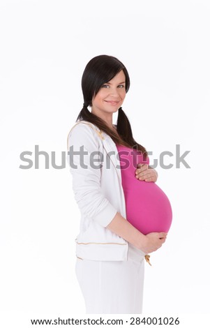 Young pregnant woman waiting for baby. Girl in sports suit and T-shirt keeping her future life.