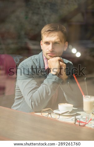 Man thinking about organization of his work schedule. Cute and serious startupper looking into the window.