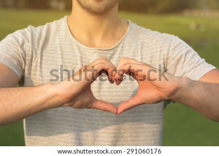 Heart symbol by man. Man making heart with his hands isolated on his T-shirt.