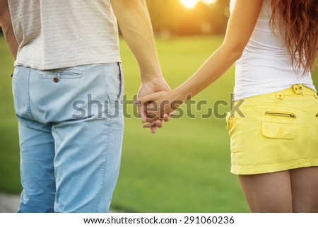 Young couple in love. Honeymoon couple romantic in love holding hands in the sunset.