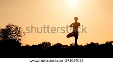 Black silhouette of yogi girl with her hands clasped on front of her chest. Beautiful girl with ideal back posture practicing.