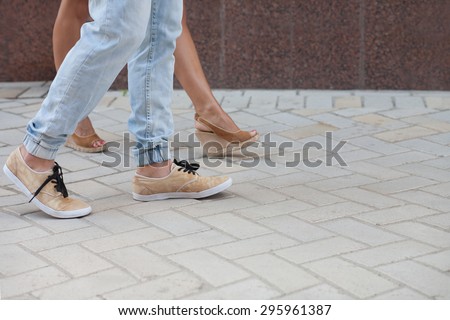Legs of young man and woman walking in the European city. Young people in love with each other.