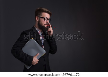 Hipster bearded businessman talking over mobile phone. Serious and industrious short-haired man in glasses keeping documents.