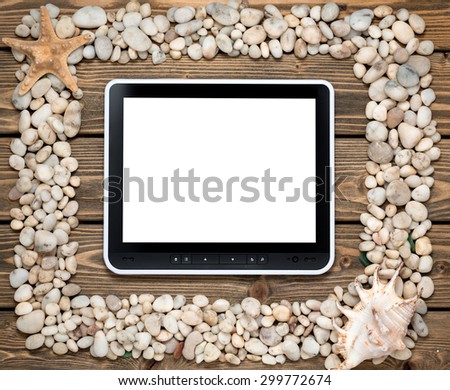 Portrait of tablet PC in the middle of frame from sea shells and stones. Vintage greeting card with shells and starfishes and place for text.