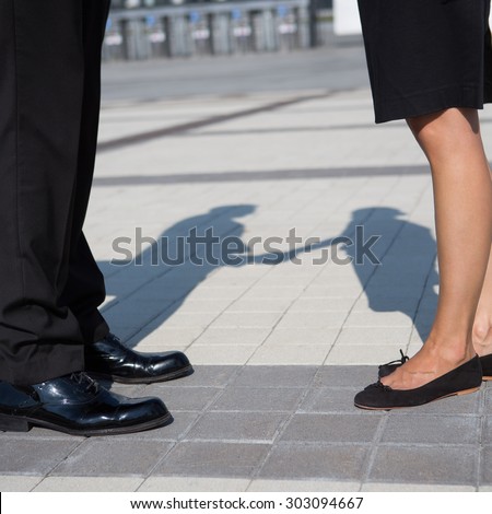 Two business partners shaking hands. Man and woman have signed the promising contrant between their enterprises.