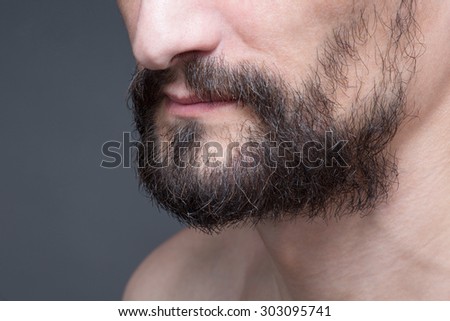 Close-up portrait of short beard and mustache with naked bearded man. Middle-aged man demonstarting his black beard.