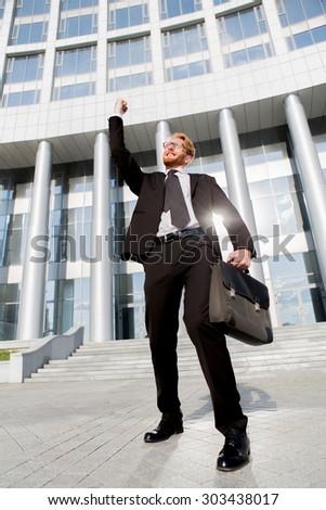 Portrait of confident and motivated businessman. Successful man is standing in formal suit with brief case. Outdoor business concept.