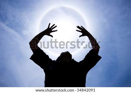 person with hands up around Halo - sunlight  phenomenon