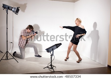 Young model poses for young photographer  in photo studio