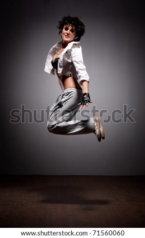 Portrait of jumping dancing woman in street style