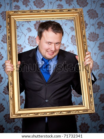 Portrait of businessman in golden frame on wallpapers background