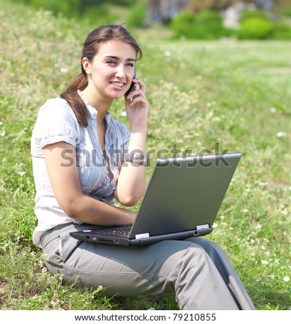 Beautiful woman with notebook sit on green grass in park