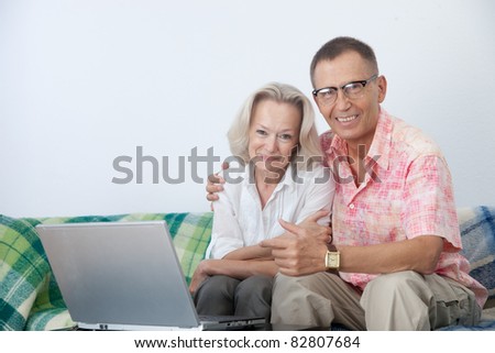 Happy pair on sofa with notebook
