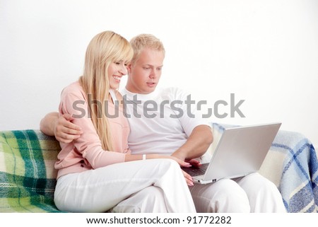 Happy couple on sofa with notebook