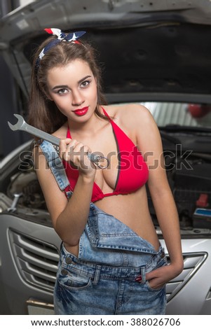 Young women engineer holding wrench in hand. Lady going to repair car at service station.