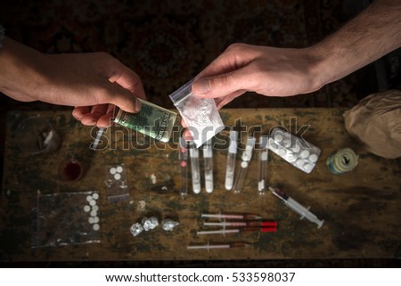 Purchase, possession and sale of drugs is punishable by law. Many types of narcotics and drugs represented on table.