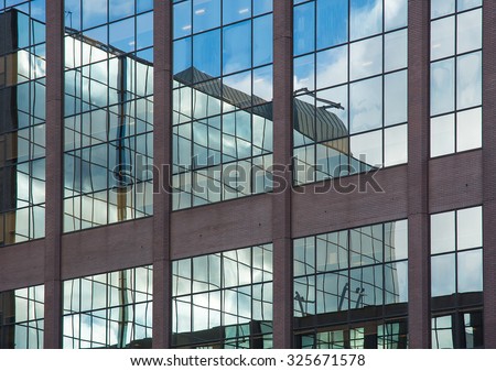 reflections in the glass wall of an office block in the commercial and financial centre of Birmingham, UK