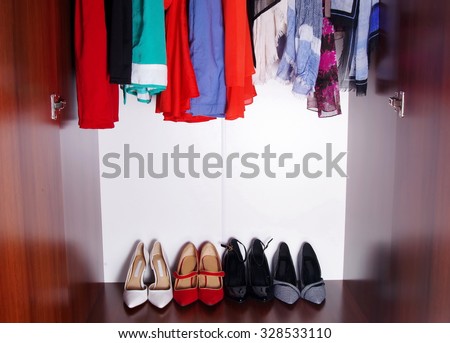 wardrobe with hanged clothes and shoes closeup