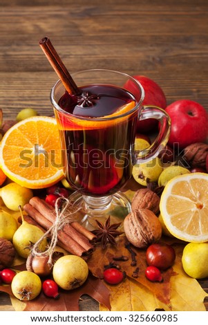 Mulled wine with spices and autumn decor on wooden table. Close up