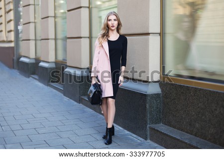 Young beautiful woman standing on the street. Elegant outfit. Full body portrait. Female fashion.