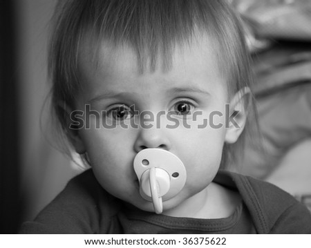 Cute little girl with a pacifier, black and white