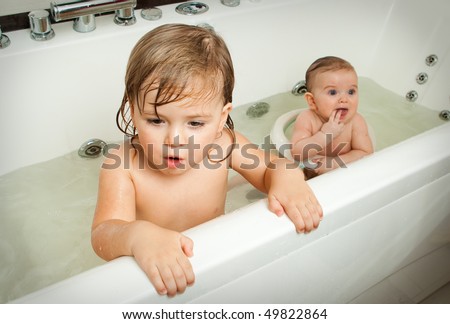 Adorable little brother and sister having fun taking a bath