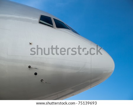 Airplane nose details against clear blue sky