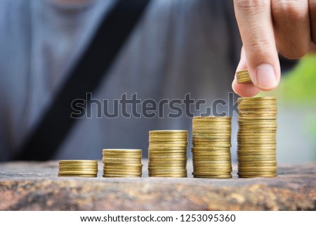 Save money concept with hand putting the coin on coin stack growing business