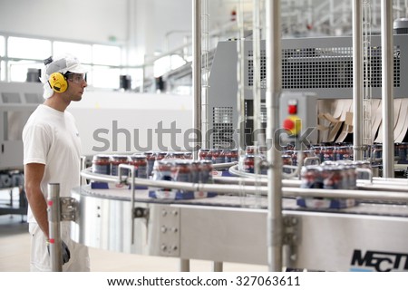 PARMA, ITALY - 3 OCTOBER 2012: Cellophane-wrapped packages of filled pasta sauce jars travelling along a conveyor belt inside a pasta factory.
