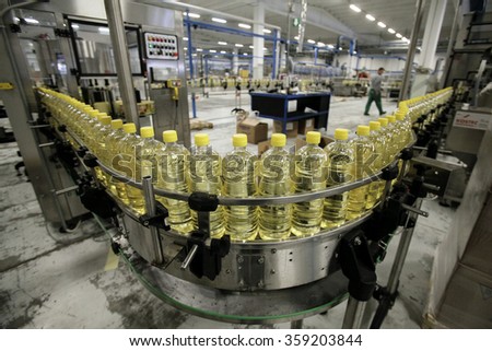 BENEVENTO, ITALY - 12 NOVEMBER 2012: Bottles of olive oil travelling along the production line inside a factory for the production of edible oils.