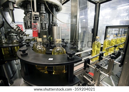 BENEVENTO, ITALY - 12 NOVEMBER 2012: Bottles of olive oil travelling along the production line inside a factory for the production of edible oils.