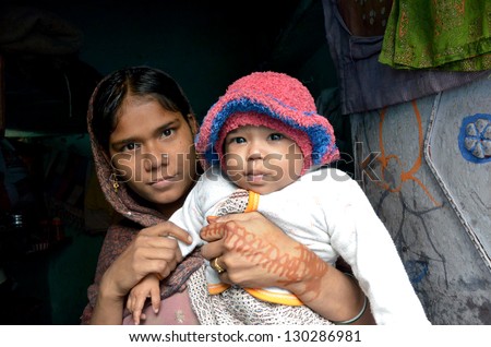 NEW DELHI,INDIA-FEBRUARY,4: a young Indian mother with her child who lives in the poorest district of New Delhi in February 4,2013.50% of the population of New Delhi is thought to live in slums