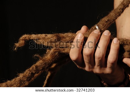 a tuft of hair dreads in hand