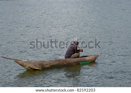 MALAWI LAKE, MALAWI- APRIL 13: Fisherman absorbed in thought in his canoe in the middle of Malawi lake in Malawi, on April 13, 2011.Fishing is the major source of livelihood  in Malawi.