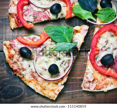 pizza with salami, olives and cheese cut into chunks