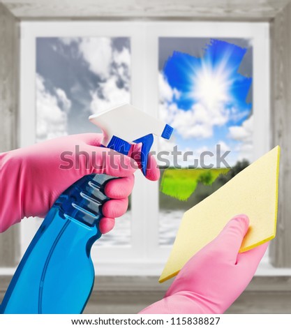 hands in pink gloves with means clears the dirt from the window