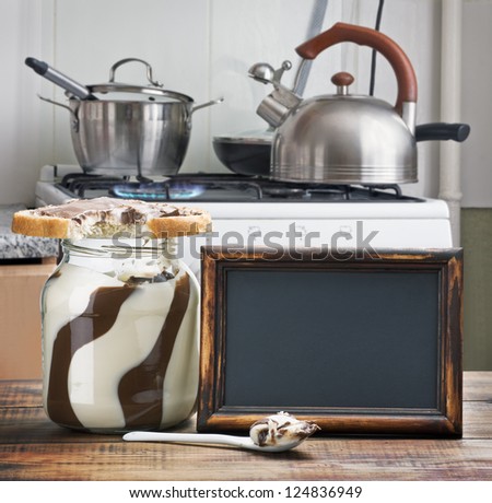 bitten sandwich with chocolate paste and a blackboard on the background of kitchen ware