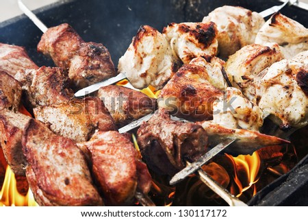 juicy slices of pork and chicken cooked over a fire. kebab.