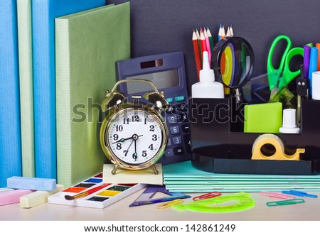 alarm clocks and school supplies on the school desk