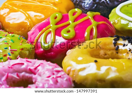 Glazed donuts in the range of background. Focus on the pink donut.