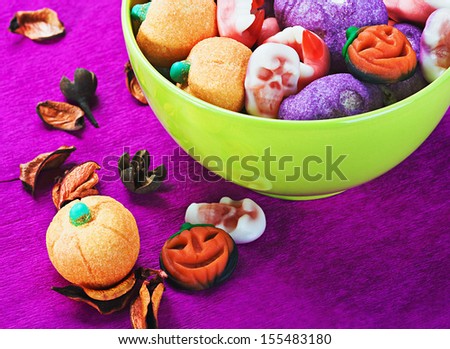 sweets and candies for the holiday Halloween. Focus on the pumpkin in the foreground