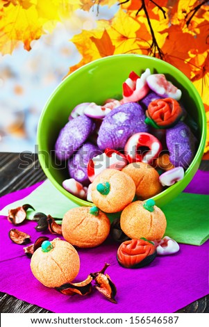 sweets and candies for the holiday halloween on a background of leaves and sky
