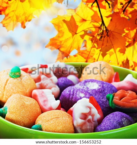 sweets and candies for the holiday halloween on a background of leaves and sky