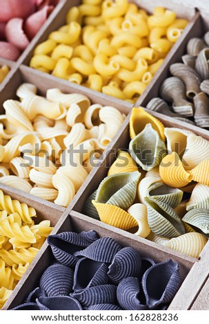 Italian pasta assortment of different colors background. Focus on the black pasta