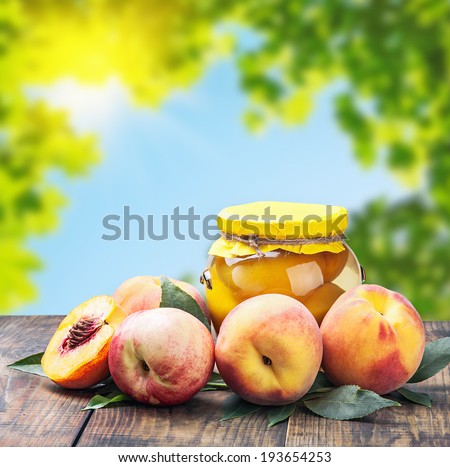 fresh and canned peaches on nature background