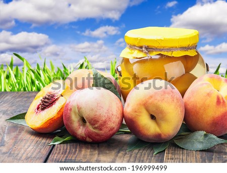 fresh and canned peaches on a sky background