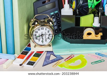 alarm clocks and school supplies on the school desk