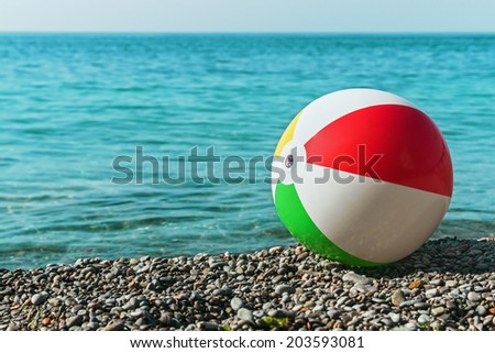 children\'s ball on the beach against the sea. Focus on the valve to inflate the ball